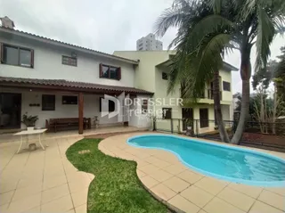 Vista externa de uma piscina e jardim em uma propriedade.