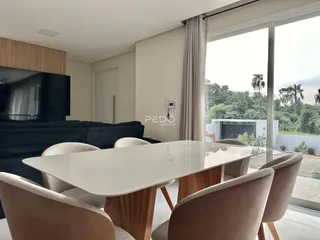 Sala de jantar com mesa de vidro e cadeiras em um imóvel no Brasil.
