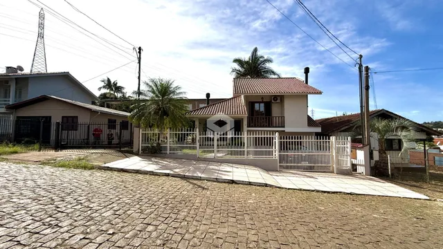 Foto da fachada de uma residência em Lajeado, Brasil, com cerca e paisagismo.