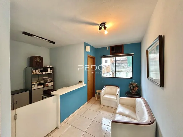 Sala de estar com paredes azuis e piso de cerâmica em um imóvel no Brasil.