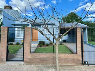 Fachada de uma residência com muro de tijolos vermelhos em Lajeado, Brasil.