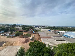 Vista aérea de uma área de terra com estruturas industriais e vegetação.