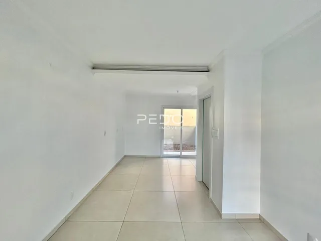 Corredor interno de uma residência com paredes brancas e piso claro.