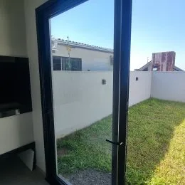 Vista externa mostrando um gramado verde e uma parede branca.