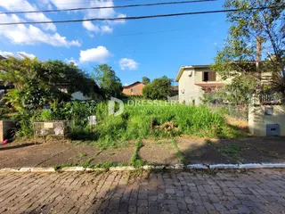 Vista da fachada de uma propriedade em Lajeado, Brasil, com vegetação alta no quintal.