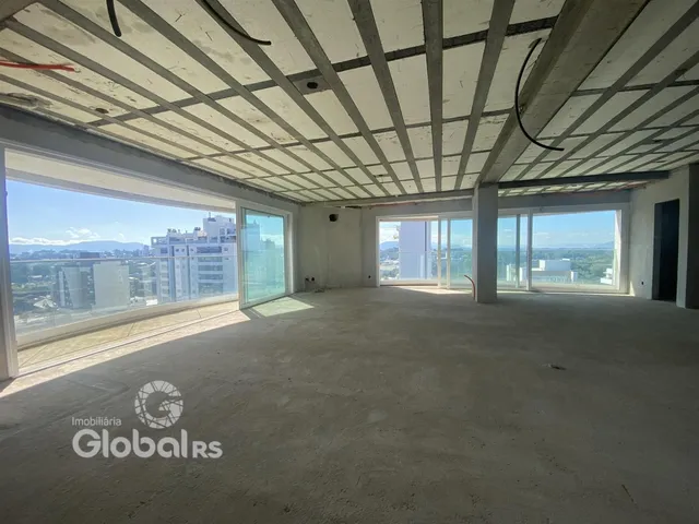Espaço interno amplo com teto de concreto aparente e grandes janelas.
