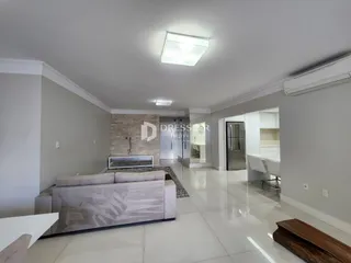 Sala de estar moderna com piso de porcelanato claro e sofá cinza.
