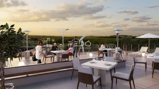 Vista de uma área de lazer externa com mesas e cadeiras em um terraço ao pôr do sol.