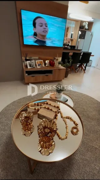 Sala de estar com televisão montada na parede.