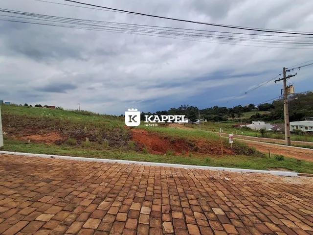Vista externa de uma área com terra e vegetação ao fundo.