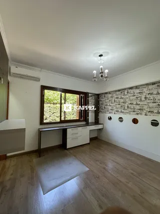Foto de uma cozinha com bancadas brancas e janela de vista para o exterior.