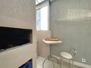 Uma parede interna com uma televisão montada e um móvel simples.