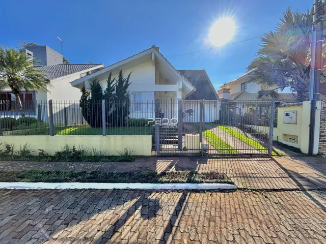 Fachada de uma casa em Lajeado, Brasil, com cerca e jardim na frente.
