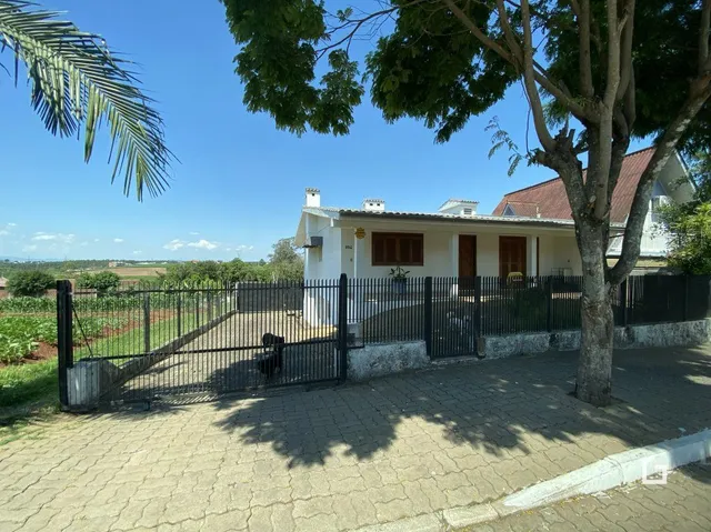 Fachada de uma casa em Lajeado, Brasil com cerca e paisagismo.