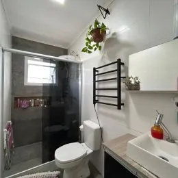 Foto interna de um banheiro com revestimento e vaso sanitário.
