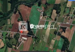 Vista aérea de uma propriedade rural com campos e vegetação.