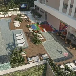Vista externa mostrando uma área de jardim com piso e vegetação.