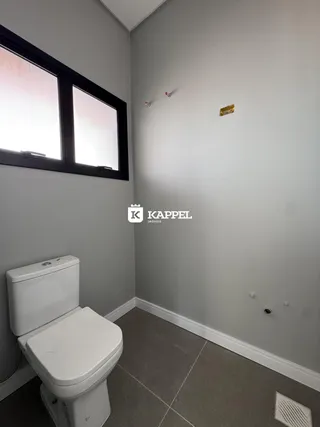 Foto de um banheiro com paredes cinzas e uma janela.