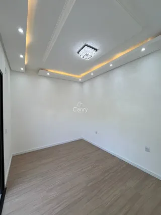 Ambiente interno com piso de madeira e iluminação embutida no teto.