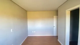 Foto de um ambiente interno com paredes cinzas e piso de madeira clara.