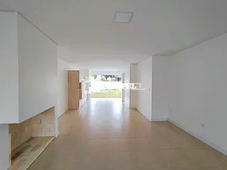 Corredor longo com piso de cerâmica e lareira à esquerda, com vista para o exterior.