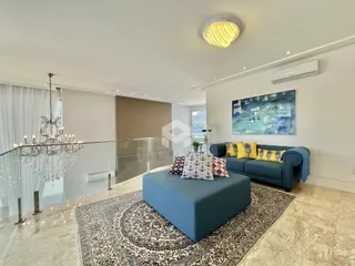 Sala de estar moderna com sofá azul e piso de mármore claro.