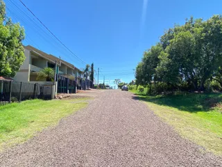Vista da rua de terra em Lajeado, Brasil, com residências e vegetação ao longo da via.