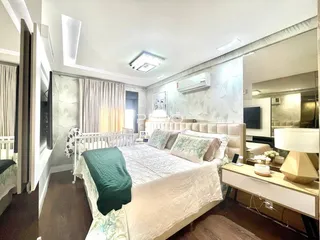 Quarto com cama grande e decoração clara em um imóvel no Brasil.