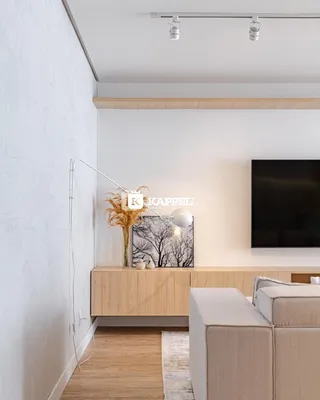 Sala de estar com painel de madeira e televisão na parede.