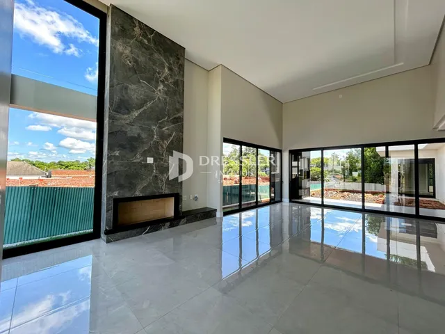 Sala de estar com piso de porcelanato e grandes janelas de vidro.
