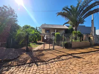 Fachada de uma residência com portão de ferro na rua.