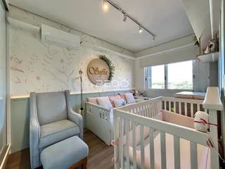 Quarto com paredes decoradas e berços brancos em um imóvel no Brasil.