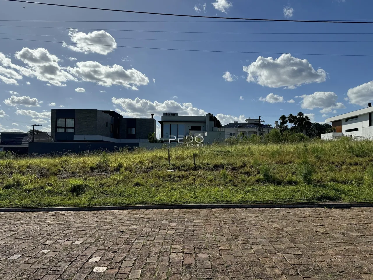 Vista da fachada de uma residência moderna em Lajeado, Brasil, com gramado em primeiro plano.