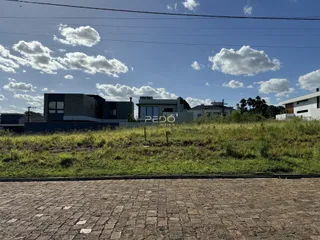 Vista da fachada de uma residência moderna em Lajeado, Brasil, com gramado em primeiro plano.