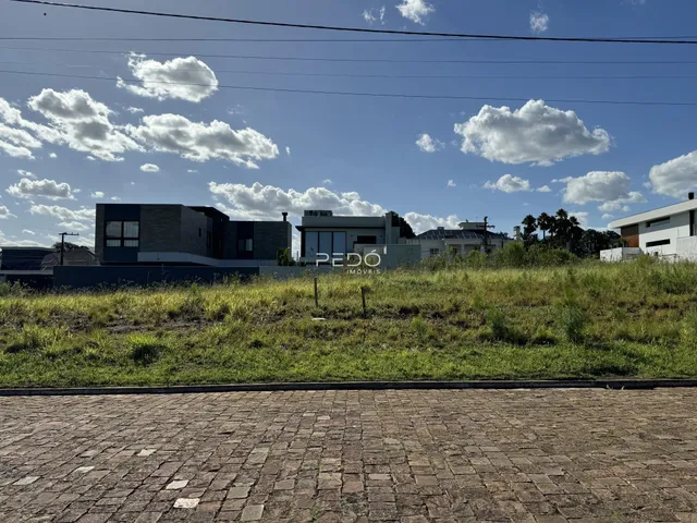 Vista da fachada de uma residência moderna em Lajeado, Brasil, com gramado em primeiro plano.