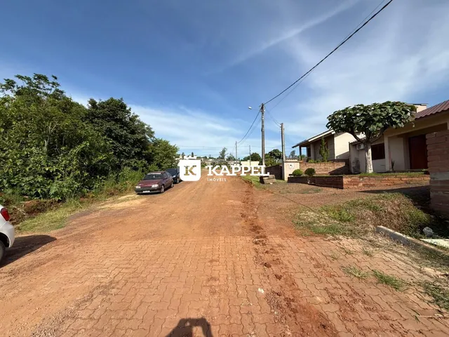 Vista externa de uma propriedade com estrada de terra vermelha.