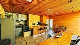 Ambiente de sala de jantar e cozinha com acabamento em madeira.