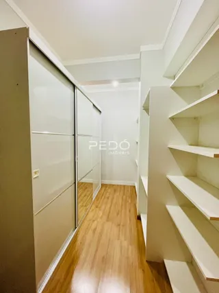 Hall de entrada com piso de madeira e paredes brancas.