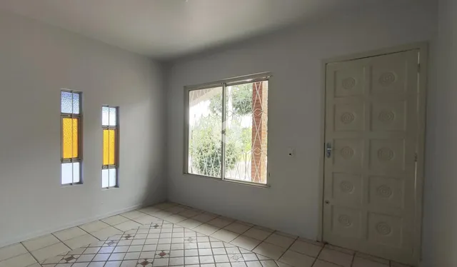 Foto de um cômodo interno com paredes brancas e piso de cerâmica.