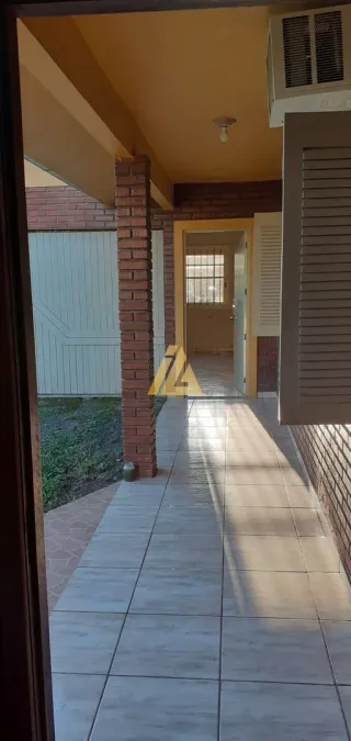 Hall de entrada com piso de cerâmica e coluna de tijolos aparentes.