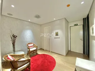 Sala de estar com móveis de vime e tapete vermelho em um imóvel no Brasil.