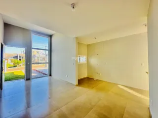 Sala de estar com porta de vidro abrindo para o quintal.