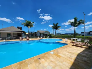 Vista aérea de uma piscina externa com deck de pedra em uma residência em Lajeado.