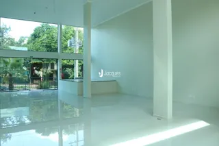 Interior de uma sala de estar com grandes janelas de vidro.