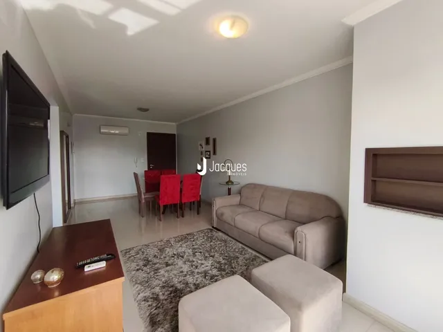 Sala de estar com sofá e mesa de jantar em um apartamento.