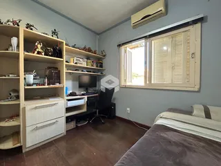 Quarto com estantes de madeira e janela no interior de uma residência.