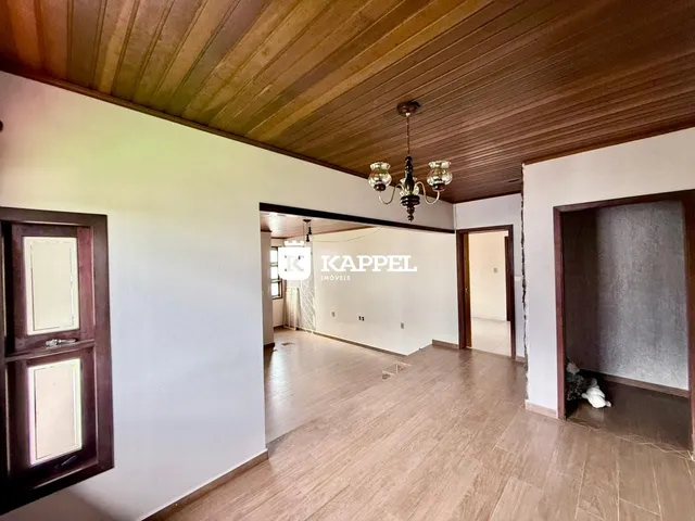 Ambiente interno com forro de madeira e piso claro em uma sala.