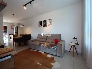 Sala de estar com sofá e tapete em um apartamento.