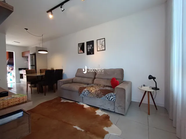 Sala de estar com sofá e tapete em um apartamento.