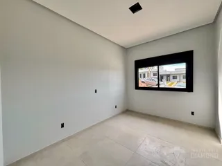 Uma sala interna com paredes brancas e piso de cerâmica.